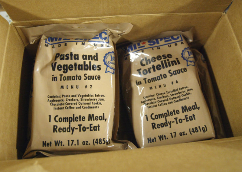 Two Meal, Ready-to-Eat (MRE) packages in a cardboard box