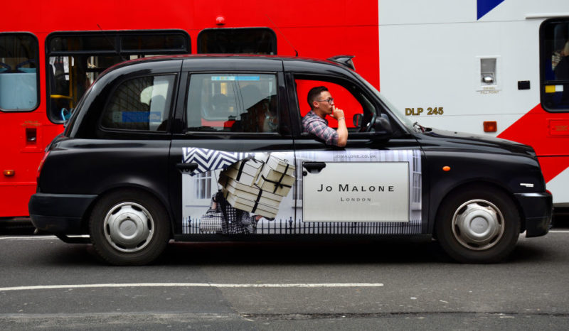 Taxis driving by a city bus