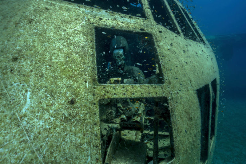 Pilot dummy sitting within the cockpit of a sunken Lockheed C-130 Hercules