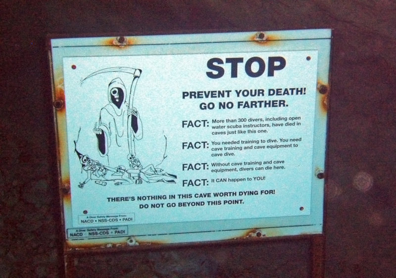 Underwater sign reading, "STOP. PREVENT YOUR DEATH! GO NO FARTHER."