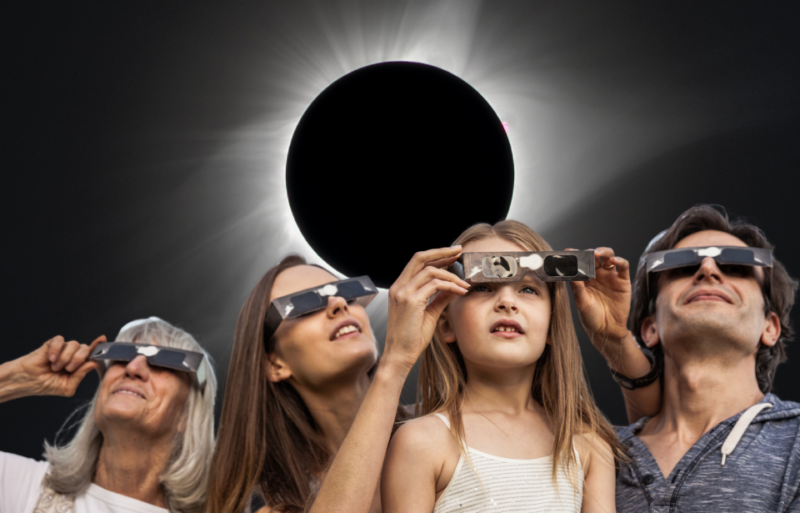 Moon moving in front of the Sun during a total solar eclipse + Four members of a family wearing eclipse glasses
