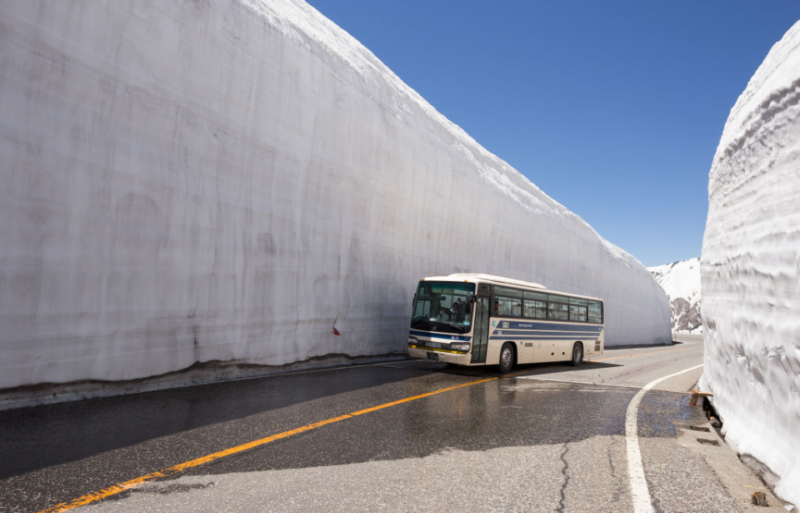 Bus driving through the Tateyama Snow Corridor