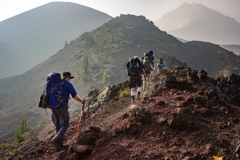 Hikers walking in a line across a rocky ledge