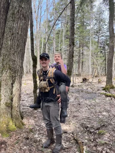 Search and rescue personnel giving Nante Niemi a piggyback ride