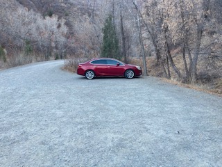 Red car parked in a gravel parking lot