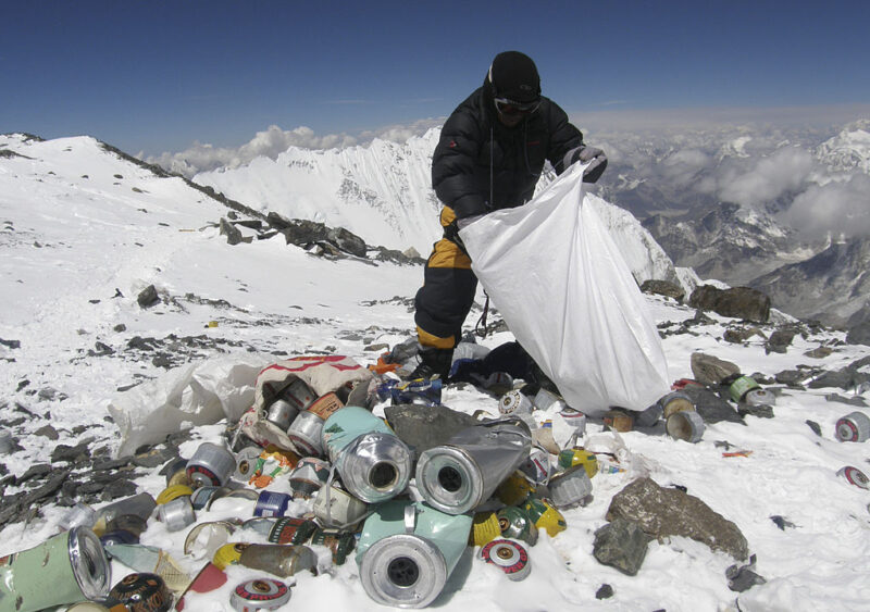 Sherpa cleaning garbage scattered in the snow