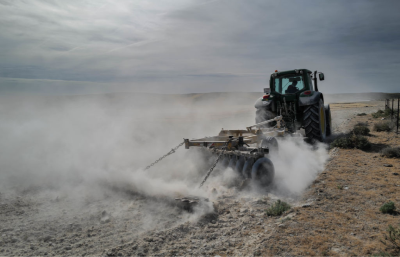 Tractor driving through a dry field in Mediana de Aragon
